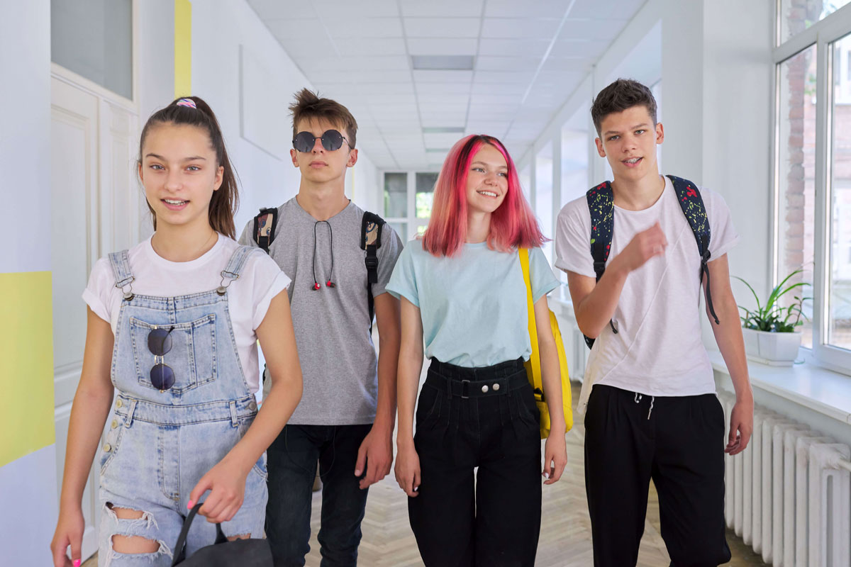group-teenage-students-walking-together-along-school-corridor-schoolchildren-smiling-talking-education-high-school-adolescence-concept